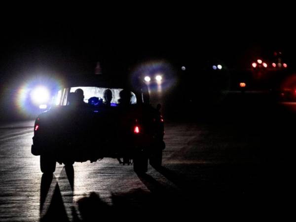 Fotografía de un vehículo que transita por una calle durante uno de los apagones que ha sufrido La Habana.