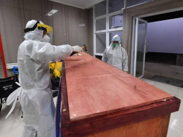 Un trabajador del hospital clava un ataúd con el cuerpo de un paciente que sucumbió al coronavirus COVID-19, en el hospital general de Bogor en Bogor, Java Occidental. Foto: Agencia AFP.