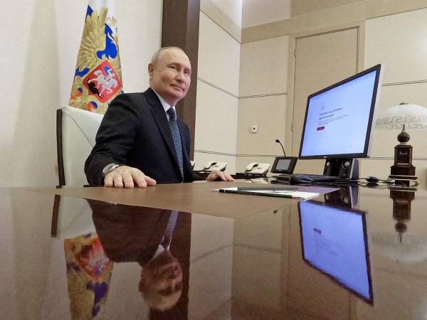 En esta fotografía de grupo distribuida por la agencia estatal rusa Sputnik, el presidente ruso Vladimir Putin vota en línea en las elecciones presidenciales en la residencia estatal Novo-Ogaryovo, en las afueras de Moscú.