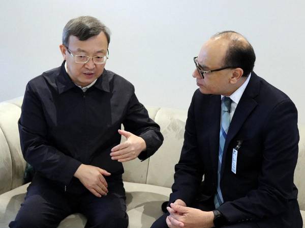 El Viceministro de Comercio de China, Wang Shouwen, habla con Melvin Redondo, Viceministro de Desarrollo Económico de Honduras, en el Aeropuerto Internacional de Palmerola en Comayagua.