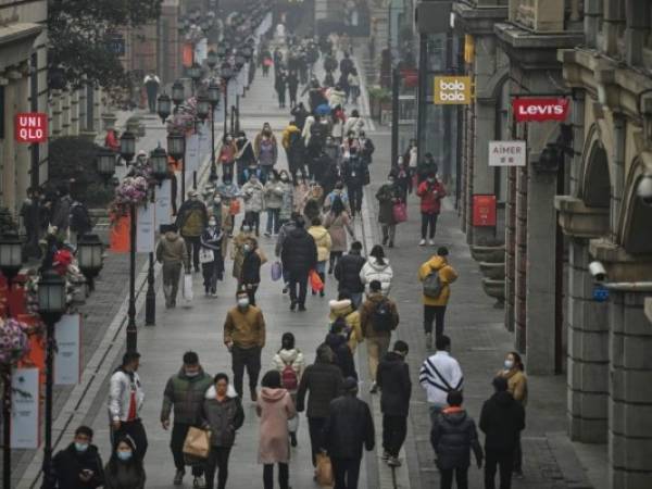 La gente camina por una calle peatonal en Wuhan, provincia de Hubei, en el centro de China, el 23 de enero de 2021, un año después de que la ciudad se bloqueara para frenar la propagación del coronavirus covid-19. Foto: AFP