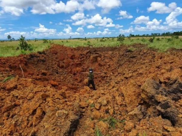 Un miembro de las Fuerzas Armadas muestra uno de los cráteres tras la explosión. Foto: Cortesía.