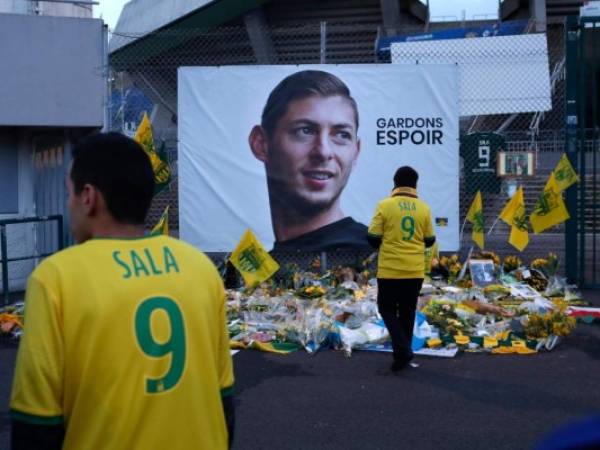 En esta foto del 30 de enero de 2019, hinchas del Nantes rinden un homenaje ante un afiche del futbolista argentino Emiliano Sala, con la leyenda 'mantengamos la esperanza'. La FIFA ha ordenado que el Cardiff pague al Nantes por la transferencia del jugador, fallecido en un accidente aeronáutico. (Foto: AP)