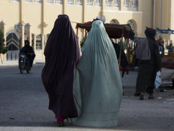 Mujeres vestidas con burka caminan por una calle en Kandahar el 7 de mayo de 2022.