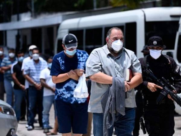 El alcalde de Zacatecoluca, Francisco Salvador Hirezi Morataya, es escoltado por miembros de la Policía Nacional Civil tras ser detenido por cargos de corrupción en San Salvador. FOTO: AFP