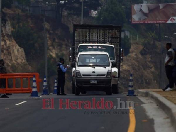 Un policía revisa la documentación de un vehículo que ingresaba a Tegucigalpa el domingo 26 de abril. La circulación está prohibida en Honduras, salvo para los empleados de las labores esenciales durante la emergencia contra el Covid-19. Foto: Emilio Flores / EL HERALDO.