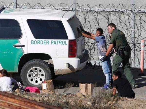 Momento en el que un agente fronterizo de Estados Unidos detiene a un migrante en la frontera. (Foto: Referencia AP)