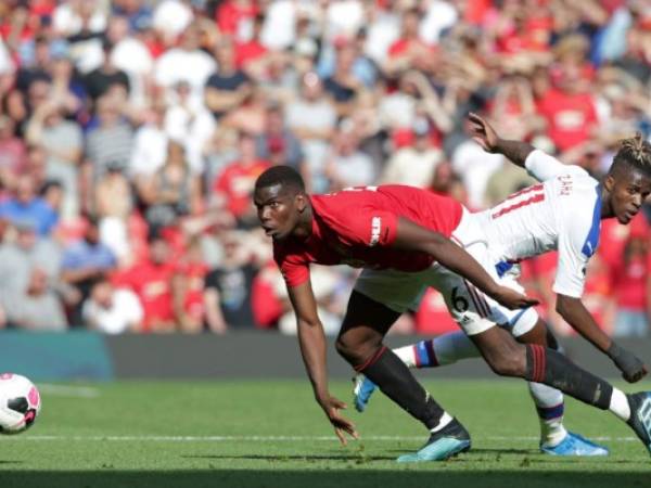 El mediocampista francés del Manchester United Paul Pogba compite con el delantero marfileño de Crystal Palace Wilfried Zaha durante el partido de fútbol de la Premier League. Foto: Agencia AFP.