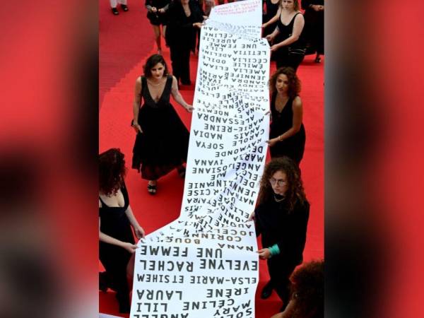 Miembros del movimiento feminista “Les Colleuses” sostienen una pancarta con los nombres de 129 mujeres que murieron como consecuencia de la violencia doméstica desde el último Festival de Cine de Cannes, en la alfombra roja antes de la proyección de la película “Holy Spider” durante la 75. edición del Festival de Cine de Cannes en Cannes.