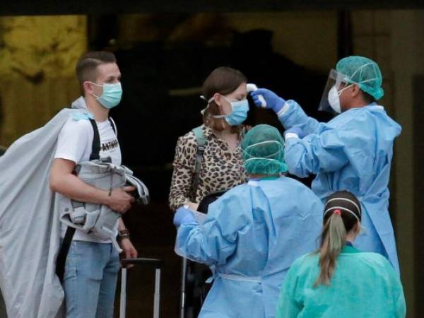 Personal sanitario toma la temperatura a una huésped del hotel H10 Costa Adeje Palace en La Caleta, en la isla canaria de Tenerife, España, el 28 de febrero de 2020. Foto: AP.