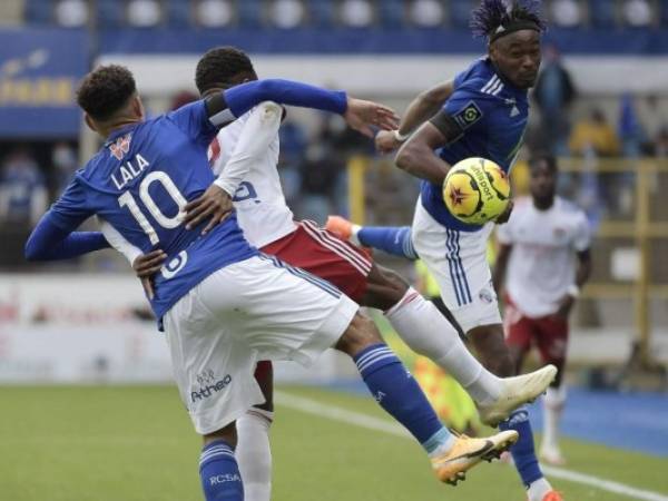 El delantero francés de Lyon Moussa Dembele (C) lucha por el balón con el defensor francés de Estrasburgo Kenny Lala durante el partido de fútbol francés L1 entre Estrasburgo (RCSA) y Lyon (OL) el 18 de octubre de 2020 en el estadio Meinau en Estrasburgo, este de Francia. Foto: AFP