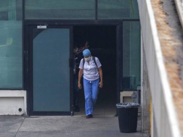 Un trabajador de la salud sale de un Ã¡rea del aeropuerto La Aurora que el gobierno destinÃ³ como albergue temporal para ciudadanos guatemaltecos deportados de Estados Unidos mientras aguardan los resultados de pruebas para determinar si tienen el nuevo coronavirus. La imagen es del miÃ©rcoles 15 de abril de 2020. (AP Foto/MoisÃ©s Castillo)