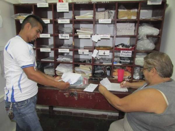 Los empleados del Correo Nacional al momento de llenar recibos de pago de los clientes. (Fotos: Juan Flores)