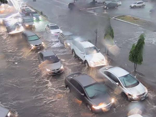 Varios vehículos tuvieron que conducirse sobre las inundadas calles a pesar del riesgo que esto implica.