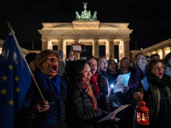 La gente canta el himno de la UE 'Oda a la Alegría' a la medianoche durante un flashmob para marcar el Brexit frente a la Puerta de Brandenburgo de Berlín. Foto. Agencia AFP.