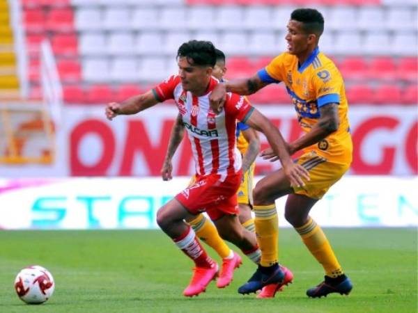 Martin Barragan, de Necaxa y Francisco Meza, de Tigres compiten por el balón durante un torneo de fútbol del Apertura mexicano. Foto: AFP