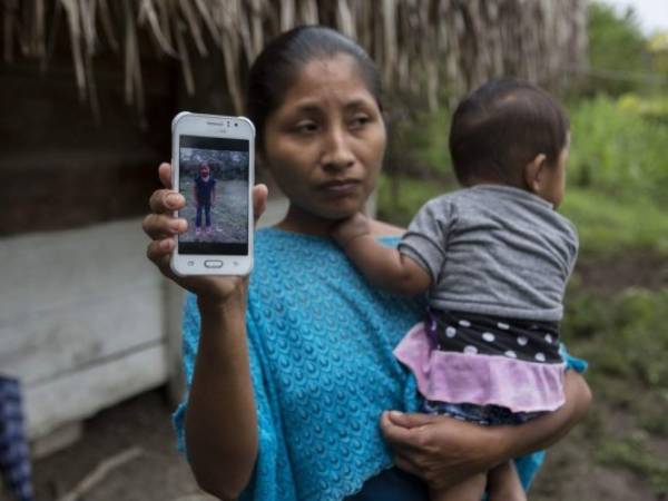 Claudia Maquin, la mamá de la niña, muestra una fotografía de su pequeña mientras sostiene al menor de sus hijos. Foto: AP