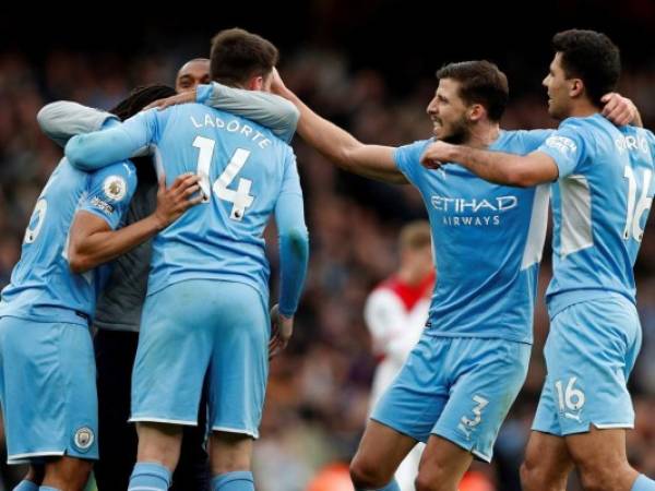 El centrocampista español del Manchester City Rodri celebra con el defensor portugués del Manchester City Ruben Dias y sus compañeros de equipo después del partido de fútbol de la Premier League inglesa entre el Arsenal y el Manchester City en el Emirates Stadium.