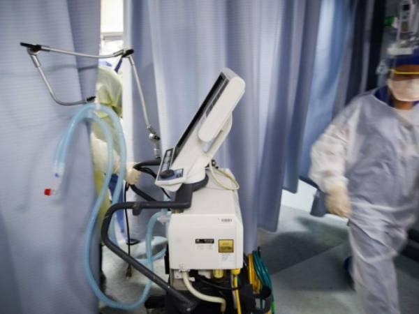 Un médico jala una máquina para respirar para examinar a un paciente de COVID-19, en el Hospital St. Joseph, el Nueva. Foto: Agencia AP.