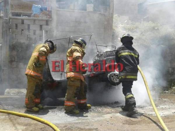 Miembros del Cuerpo de Bomberos de Honduras llegaron a la zona para apagar las llamas que consumian la mototaxi. Foto: Estalin Irías/EL HERALDO.