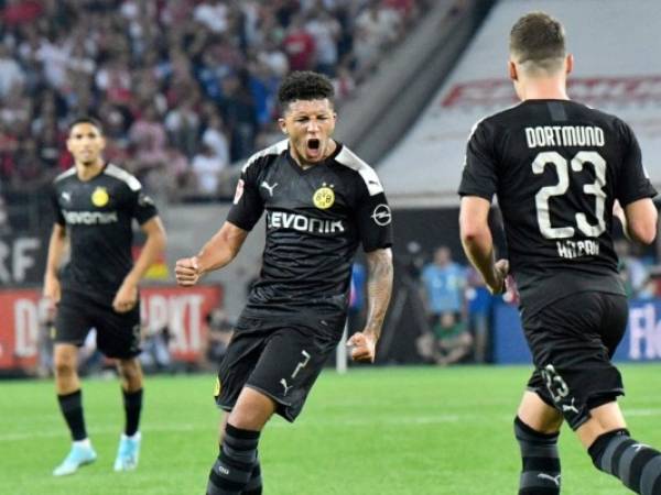 Jadon Sancho (centro) festeja con sus compañeros tras anotar el primer gol del Borussia Dortmund en la victoria 3-1 ante Colonia en la Bundesliga. Foto: AP /Martin Meissner