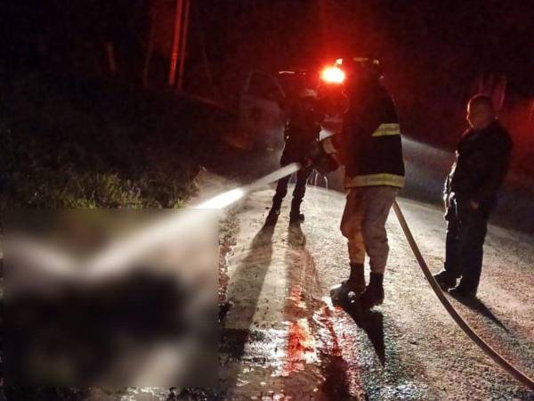 Momento en que los bomberos intentaban apagar las llamas del cuerpo carbonizado.