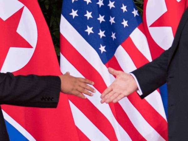 El líder de Corea del Norte Kim Jong Un saluda al presidente estadounidense Donald Trump al comienzo de su histórica cumbre entre EE. UU. Y Corea del Norte. Agencia AFP.