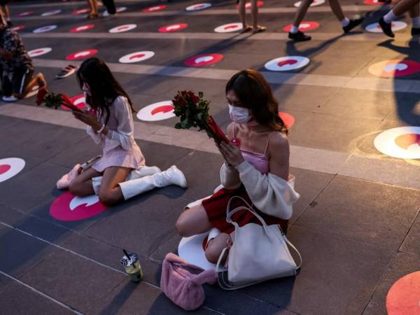 La gente reza con rosas rojas en el Santuario Trimurti, que se cree trae amor a quienes adoran ante él, en Bangkok el Día de San Valentín.