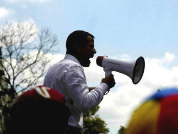 Juan Guaidó se dirige a sus seguidores con un megáfono durante una marcha registrada hace dos semanas en Venezuela. Foto: AP.