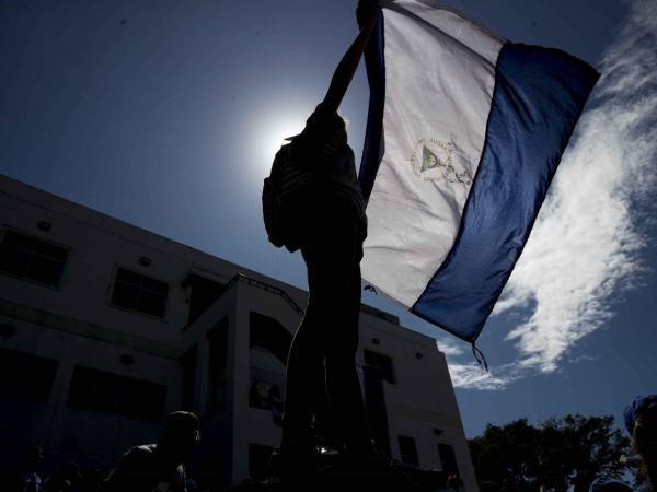 Fotografía de archivo en donde una joven sostiene una bandera nicaragüense.