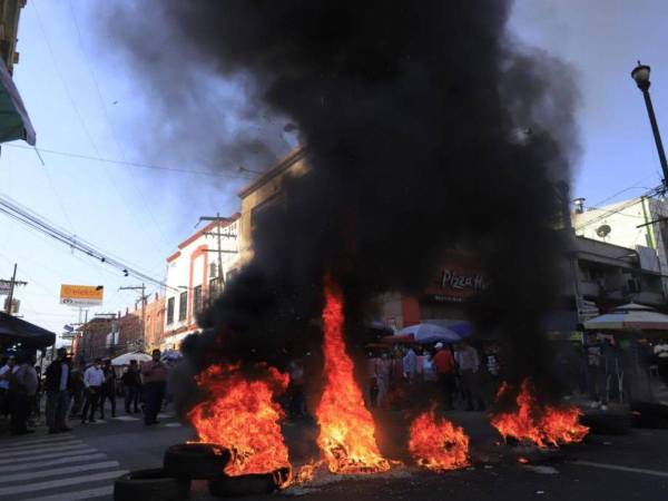 Vendedores ambulantes se agruparon en el centro de San Pedro Sula para exigir no ser desalojados de sus puestos de trabajo. Quema de llantas, paso vehicular interrumpido, negocios cerrados y amenazas al Palacio Municipal son algunos incidentes derivados de las protestas. Estas son las imágenes.