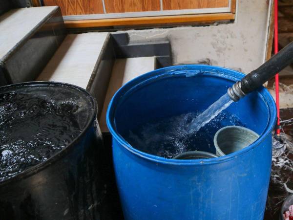 Los capitalinos llenan muchos recipientes de agua potable.