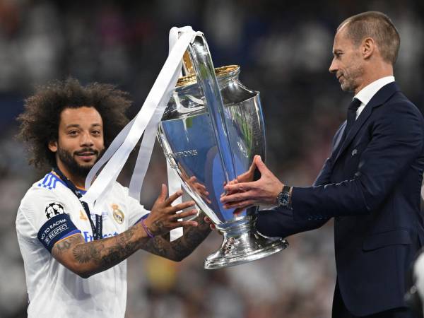 El presidente de la UEFA, Aleksander Ceferin, entrega el trofeo de la Liga de Campeones al defensor brasileño del Real Madrid, Marcelo.