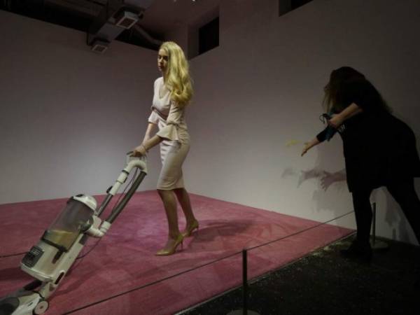 Una espectadora lanza migajas de pan para que una modelo que personifica a Ivanka Trump las aspire en la exposición de arte titulada 'Ivanka aspirando 2019'. (Foto: AP)