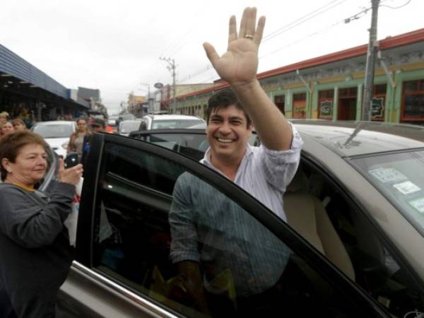 El candidato presidencial del Partido Acción Ciudadana, Carlos Alvarado, saluda a sus seguidores después de visitar un mercado público en Cartago, Costa Rica. Foto AP