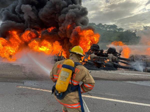 Momento en que los Bomberos apagaban el camión incendiado para recuperar el cuerpo de la víctima.