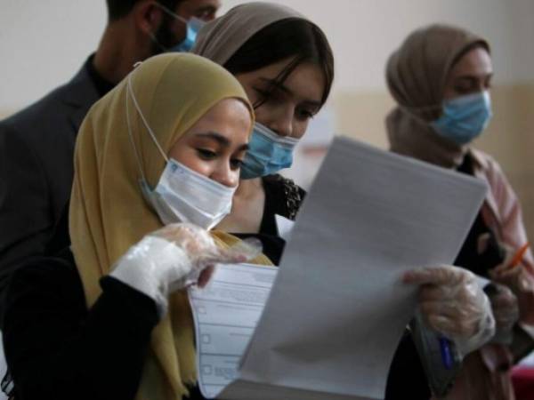 Mujeres chechenas llenan sus boletas para las elecciones parlamentarias en un lugar de votación en Grozny, Rusia. Foto: AP