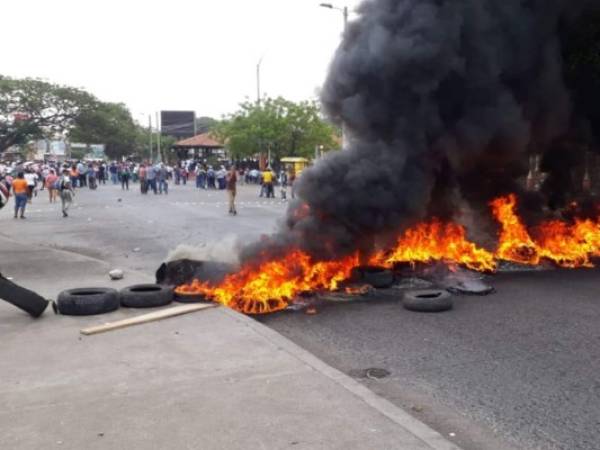 Los manifestantes queman llantas para impedir el acceso de los vehículos. Foto: EL HERALDO