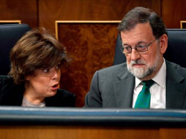 La Viceprimera Ministra española, Ministra de la Presidencia y Administraciones Regionales Soraya Sáenz de Santamaría (L) habla con el Primer Ministro español Mariano Rajoy durante un debate sobre una moción de censura presentada por el Partido Socialista Español (PSOE) en la Cámara Baja del Parlamento español. Foto AFP