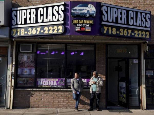 El conductor Antonio Rosario, a la izquierda, habla con Roberto Francis frente a Super Class Radio Dispatch en el distrito del Bronx de Nueva York. Foto: AP.