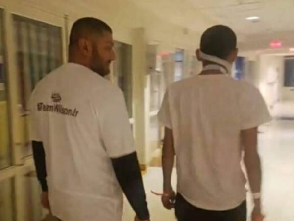 Wilson José Berríos camina por las instalaciones del hospital junto a uno de sus tíos.