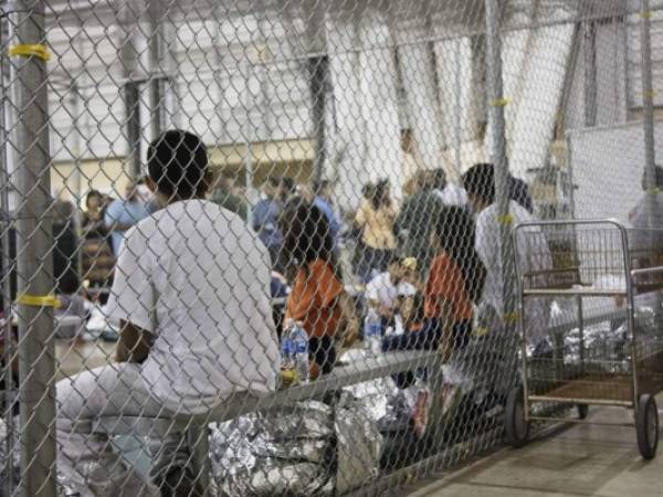 FILE - In this June 17, 2018 file photo provided by U.S. Customs and Border Protection, people who've been taken into custody related to cases of illegal entry into the United States, sit in one of the cages at a facility in McAllen, Texas. The Trump administration is under increasing pressure to speed up the reunification of immigrant families it separated at the Mexican border. Attorneys for the U.S. government and the immigrant families discussed how to accelerate the process at a hearing Friday, Aug. 31, 2018, in San Diego in front of U.S. District Judge Dana Sabraw, who set the deadline. (U.S. Customs and Border Protection's Rio Grande Valley Sector via AP, File)