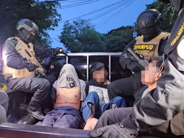 Los tres jóvenes siendo transportados por miembros de la Dirección Policial Anti Maras y Pandillas Contra el Crimen Organizado (Dipampco). “Littler Cabeza” tiene su rostro cubierto con su camisa por ser menor de edad.