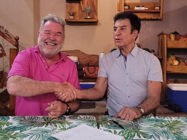 Roberto Contreras y Salvador Nasralla estrechan sus manos tras firmar la alianza.