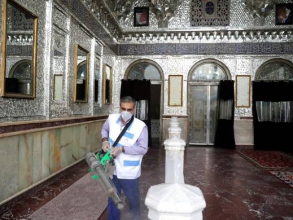 Un trabajador desinfecta un santuario islámico en Teherán el 7 de marzo del 2020. AP