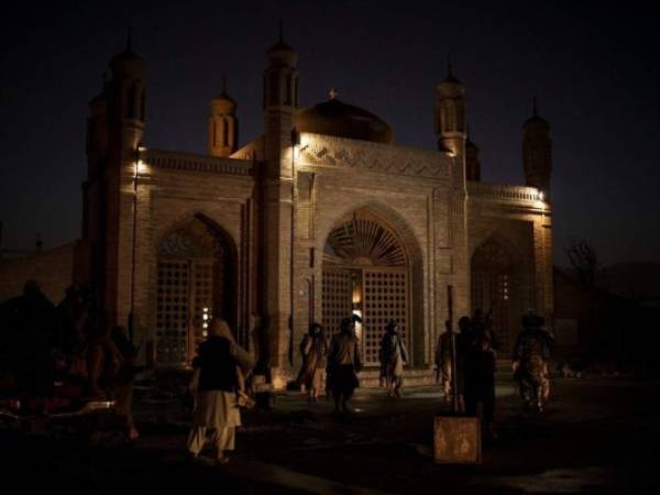 Combatientes talibanes caminan a la entrada de la mezquita Eidgah después de una explosión en Kabul, Afganistán, el domingo 3 de octubre de 2021. FOTO: AP