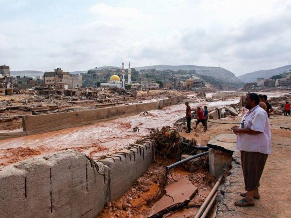 La gente observa los daños causados por las extrañas inundaciones en Derna, este de Libia, el 11 de septiembre de 2023.