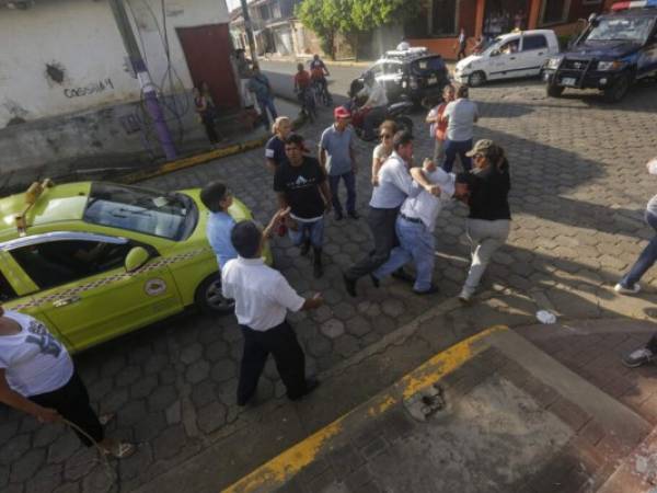 Un hombre es detenido por policía encubierta desde la Iglesia San Juan Bautista después de que ayudara a repeler a simpatizantes del gobierno del presidente Daniel Ortega cuando intentaban entrar al templo en Masaya. Foto: AP.