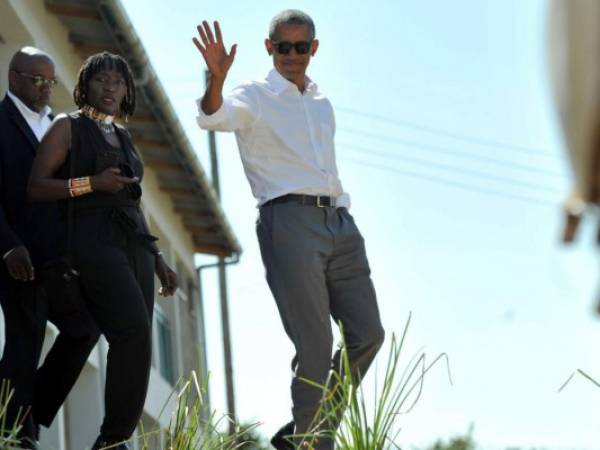 El ex presidente de los EE.UU., Barak Obama, saluda mientras camina con su media hermana, Auma. Foto AFP