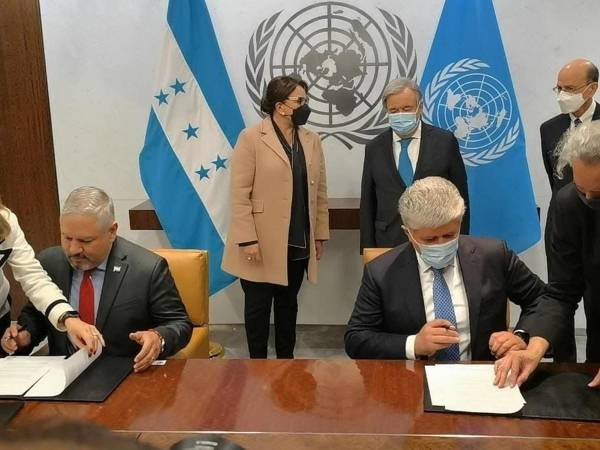 Momento en que el Canciller de la República revisa la documentación previo a la firma que da vida a la CICIH. Al fondo la presidenta de Honduras y el titular de la ONU.